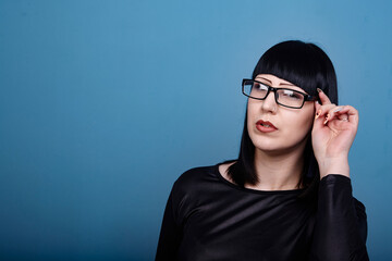portrait of a beautiful girl with glasses posing for a photographer in the studio