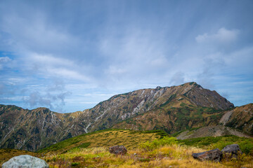 富山県立山町の立山の秋の紅葉の季節に登山している風景 Scenery of climbing Tateyama Mountain in Tateyama Town, Toyama Prefecture, Japan during the season of autumn leaves. 