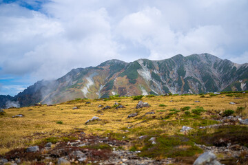 富山県立山町の立山の秋の紅葉の季節に登山している風景 Scenery of climbing Tateyama Mountain in Tateyama Town, Toyama Prefecture, Japan during the season of autumn leaves. 