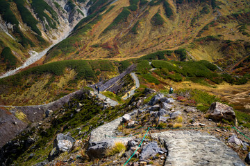 富山県立山町の立山の秋の紅葉の季節に登山している風景 Scenery of climbing Tateyama Mountain in Tateyama Town, Toyama Prefecture, Japan during the season of autumn leaves. 