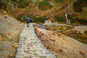 Naklejka premium 富山県立山町の立山の秋の紅葉の季節に登山している風景 Scenery of climbing Tateyama Mountain in Tateyama Town, Toyama Prefecture, Japan during the season of autumn leaves. 