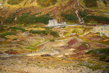 富山県立山町の立山の秋の紅葉の季節に登山している風景 Scenery of climbing Tateyama Mountain in Tateyama Town, Toyama Prefecture, Japan during the season of autumn leaves. 
