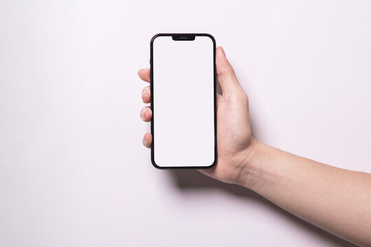 Oct 1, 2021 Bangkok, Thailand : hand holding blank screen of black iPhone 13 Pro Max Isolated on white background.