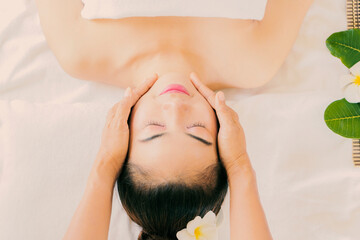 Obraz na płótnie Canvas massage the head of an Asian woman in the spa salon