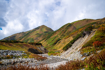 富山県立山町の立山の秋の紅葉の季節に登山している風景 Scenery of climbing Tateyama Mountain in Tateyama Town, Toyama Prefecture, Japan during the season of autumn leaves. 