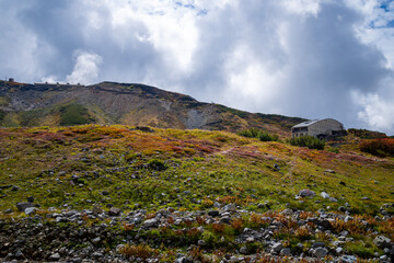富山県立山町の立山の秋の紅葉の季節に登山している風景 Scenery of climbing Tateyama Mountain in Tateyama Town, Toyama Prefecture, Japan during the season of autumn leaves. 
