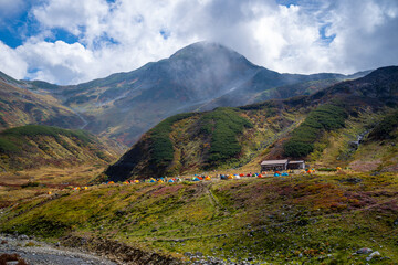 富山県立山町の立山の秋の紅葉の季節に登山している風景 Scenery of climbing Tateyama Mountain in Tateyama Town, Toyama Prefecture, Japan during the season of autumn leaves. 