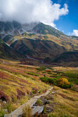 富山県立山町の立山の秋の紅葉の季節に登山している風景 Scenery of climbing Tateyama Mountain in Tateyama Town, Toyama Prefecture, Japan during the season of autumn leaves. 