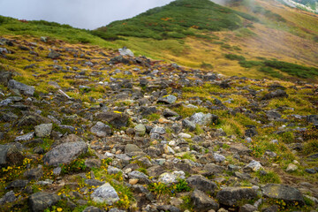 富山県立山町の立山の秋の紅葉の季節に登山している風景 Scenery of climbing Tateyama Mountain in Tateyama Town, Toyama Prefecture, Japan during the season of autumn leaves. 