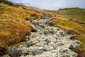 富山県立山町の立山の秋の紅葉の季節に登山している風景 Scenery of climbing Tateyama Mountain in Tateyama Town, Toyama Prefecture, Japan during the season of autumn leaves. 