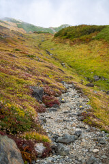 富山県立山町の立山の秋の紅葉の季節に登山している風景 Scenery of climbing Tateyama Mountain in Tateyama Town, Toyama Prefecture, Japan during the season of autumn leaves. 