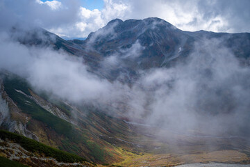 富山県立山町の立山の秋の紅葉の季節に登山している風景 Scenery of climbing Tateyama Mountain in Tateyama Town, Toyama Prefecture, Japan during the season of autumn leaves. 