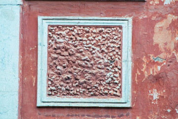 Elements of the architectural decor of the building. Fragment of the facade of an old house. Architectural stucco detail.