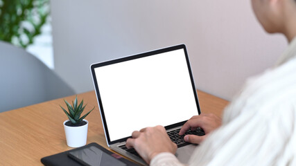 Over shoulder view of man freelancer working with laptop computer.