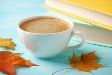Autumn background with cup of black coffee, fall leaves and books