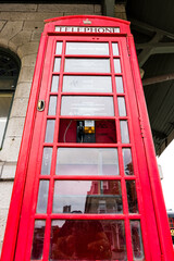 Low Angle Photograph of Red Telephone Booth at Train Station