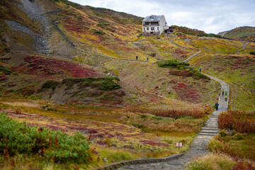 富山県立山町の立山の秋の紅葉の季節に登山している風景 Scenery of climbing Tateyama Mountain in Tateyama Town, Toyama Prefecture, Japan during the season of autumn leaves. 