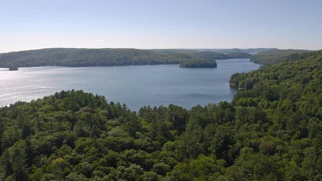 Drone shot flying over hills beside Lake of Bays Ontario Canada