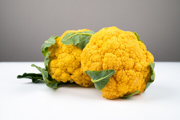 Close up f cauliflower cabbage. Yellow cauliflower with green leaves, side view