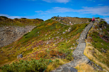 富山県立山町の立山の秋の紅葉の季節に登山している風景 Scenery of climbing Tateyama Mountain in Tateyama Town, Toyama Prefecture, Japan during the season of autumn leaves. 