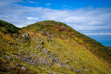 富山県立山町の立山の秋の紅葉の季節に登山している風景 Scenery of climbing Tateyama Mountain in Tateyama Town, Toyama Prefecture, Japan during the season of autumn leaves. 
