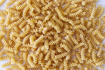 Raw Fusilli Pasta on the floor background. Traditional Italian cuisine. View from above