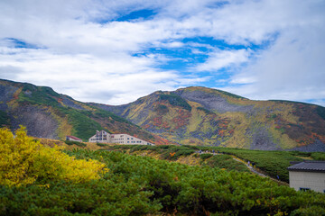 富山県立山町の立山の秋の紅葉の季節に登山している風景 Scenery of climbing Tateyama Mountain in Tateyama Town, Toyama Prefecture, Japan during the season of autumn leaves. 