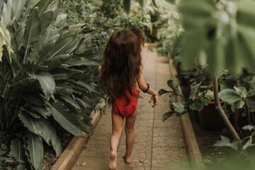 Mowgli indian little girl in a loincloth hides hiding in tropics green forest background. High quality photo