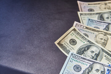 different dollar bills lie on one side on a gray background