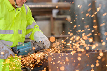 a male worker or a steelworker Skilled grinding steel and metal parts use electric grinding wheels...