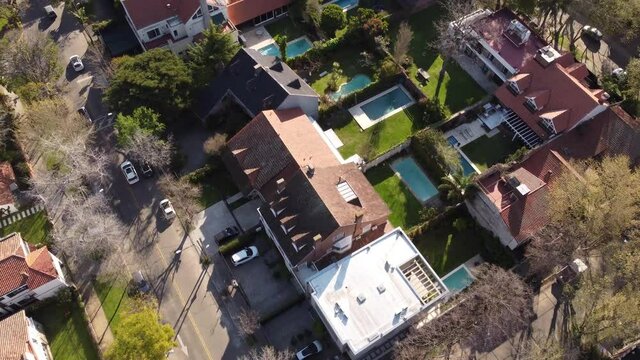 Aerial flyover luxury neighborhood with swimming pool in garden and villas in Vicente Lopez Suburb of Buenos Aires