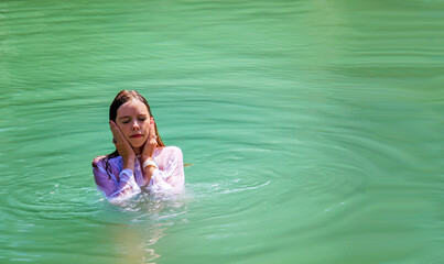 Christian Pilgrim girl take a symbolic baptism in the Jordan River in North Israel (Yardenit...