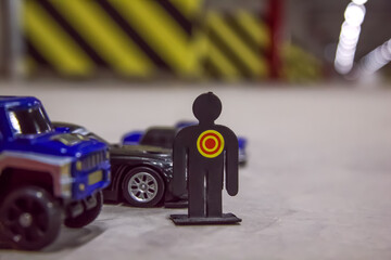 Toy car models and human's figure in a parking place in a residential building. Covered underground parking for cars