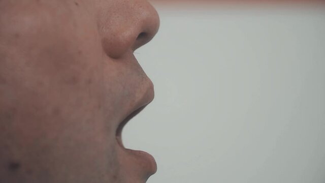 Hands in medical gloves take a swab from a man's mouth for analysis, PCR diagnostics of infections
