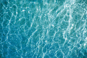 Blue water and pouring mica through a layer of glitter water. A backdrop of the sea and ocean depth