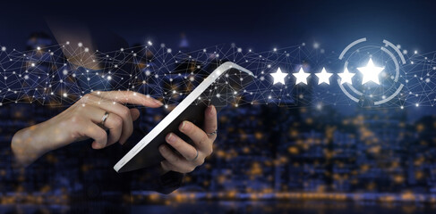 Customer Experience Concept. Hand touch white tablet with digital hologram five stars sign on city...