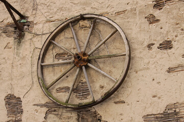 Altes Wagenrad an einer alten Wand