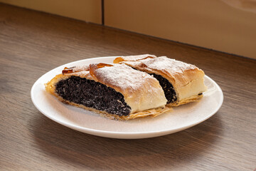 Original Hungarian homemade poppy seed strudel on a white plate