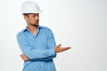 male builder in a white helmet construction industry light background