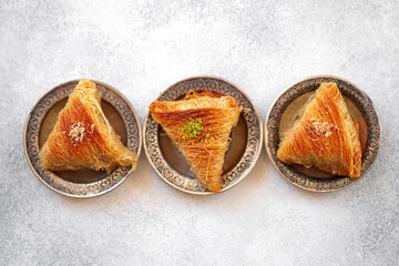 Turkish baklava on oriental metal plate on white table