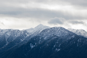 Fototapeta na wymiar Winters mountain range landscape and view, snow and cloudy sky