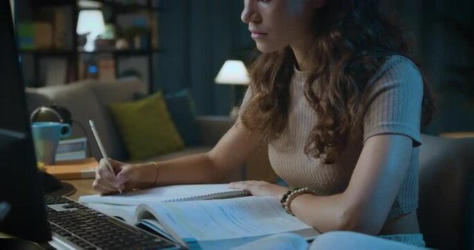 Smart young woman studying late at night