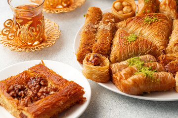 Various Turkish sweets and cup of tea on white textured background