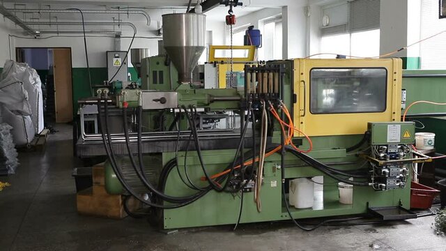 Automatic injection molding machine during operation.Plastic melting technology at the enterprise.Workshop for the production of plastic products.