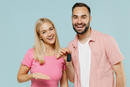 Young Smiling Happy Couple Two Friends Family Man Woman 20s In Casual Clothes Together Holding Showing Car Key Isolated On Pastel Plain Light Blue Background Studio Portrait People Lifestyle Concept.