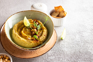 Healthy appetizer classic hummus decorated with greens and spices