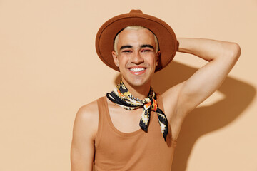 Young smiling trendy smiling happy blond latin gay man with make up in beige tank shirt neck scarf...