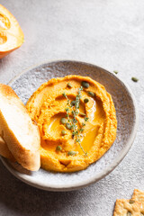 Pumpkin hummus decorated with greens and toasted bread