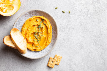 Pumpkin hummus decorated with greens and toasted bread