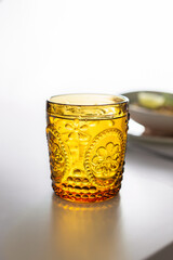 Orange glass of water for dinner on a white table